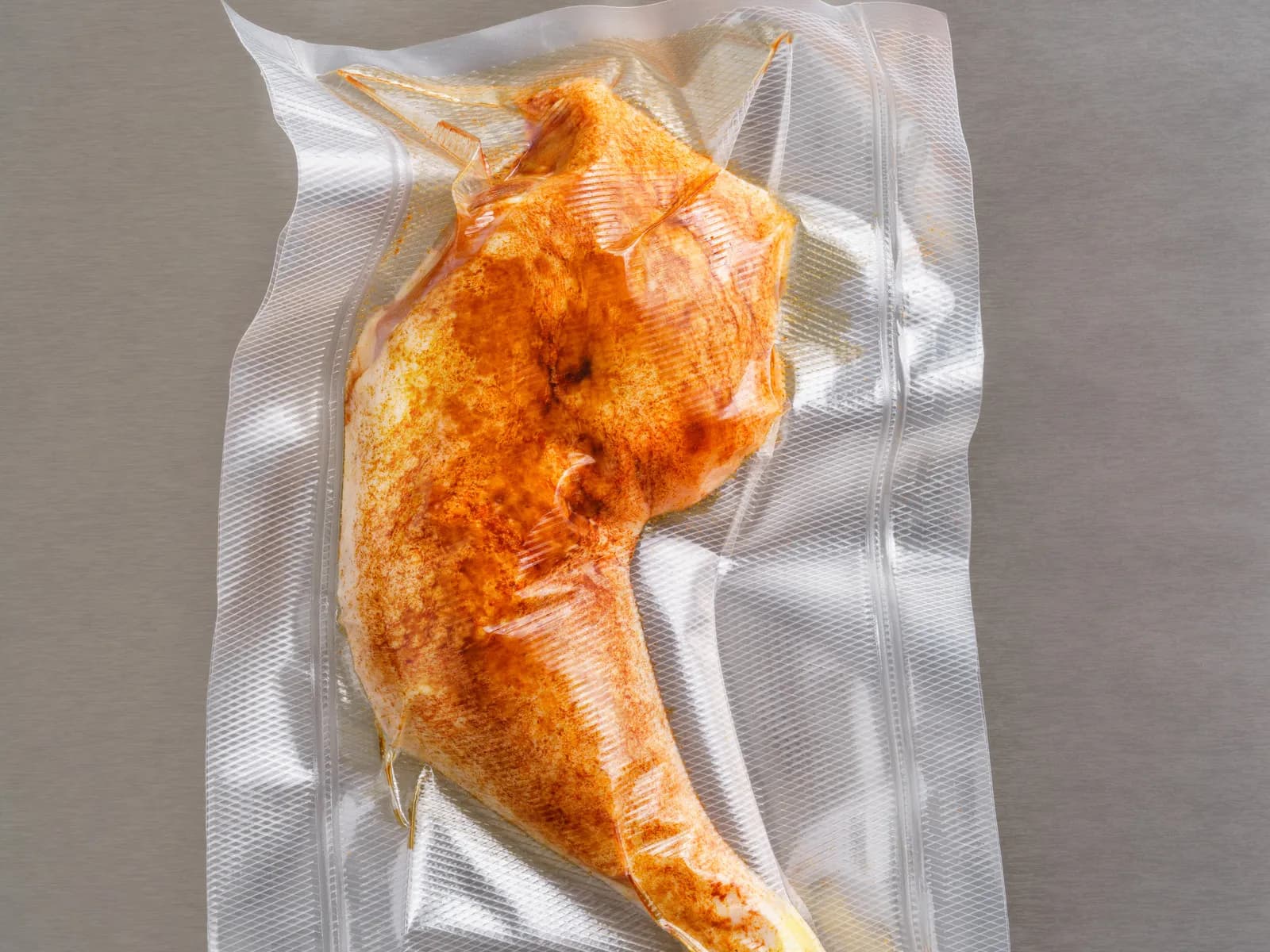 Seasoned chicken leg vacuum-packed in clear barrier film